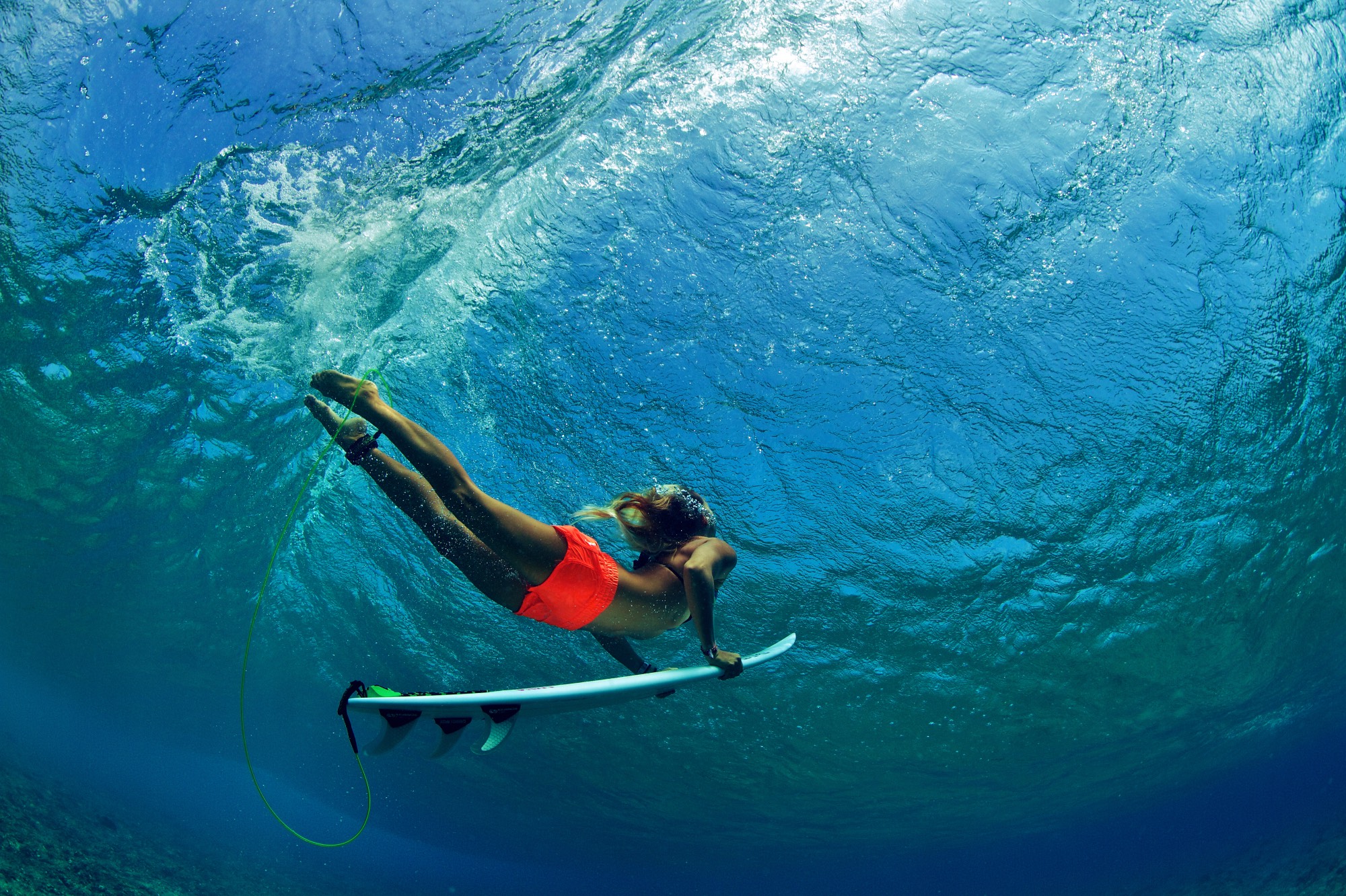 Surfer girl in orange shorts duck dives a wave Surfcenter Wustrow
